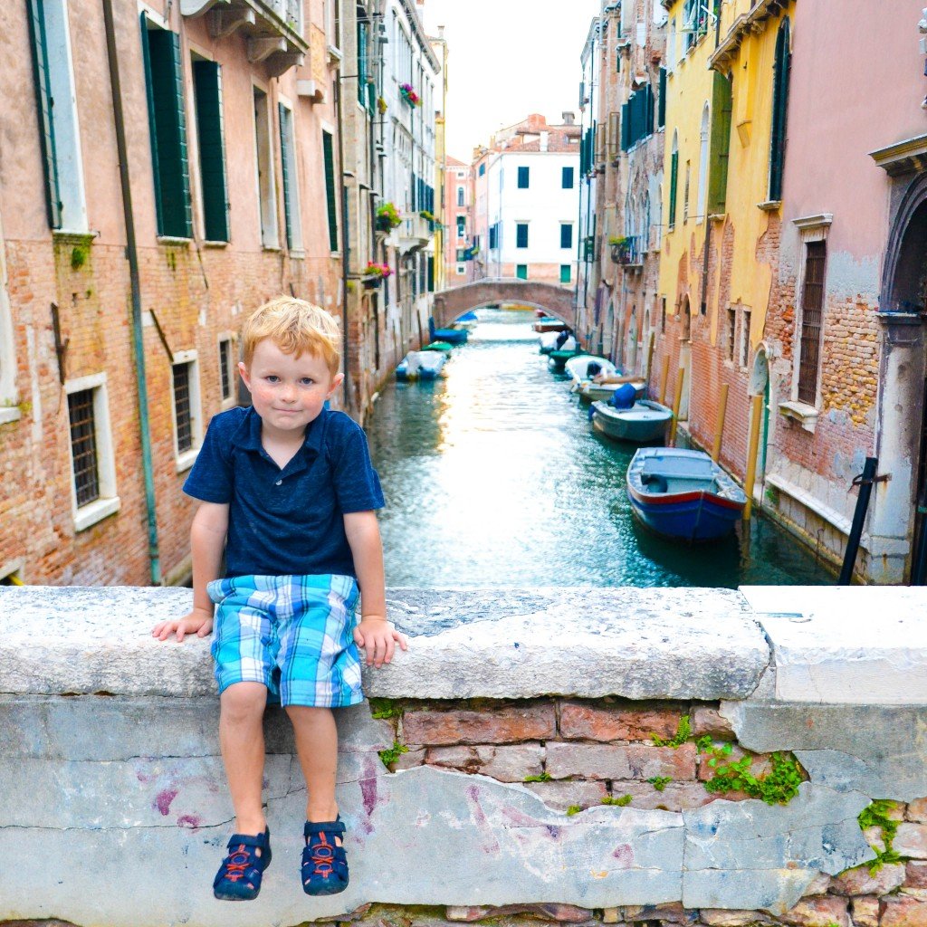 boy in front of canals in Venice