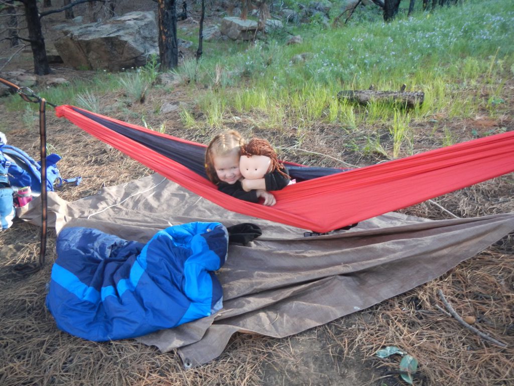little girl camping in hammock
